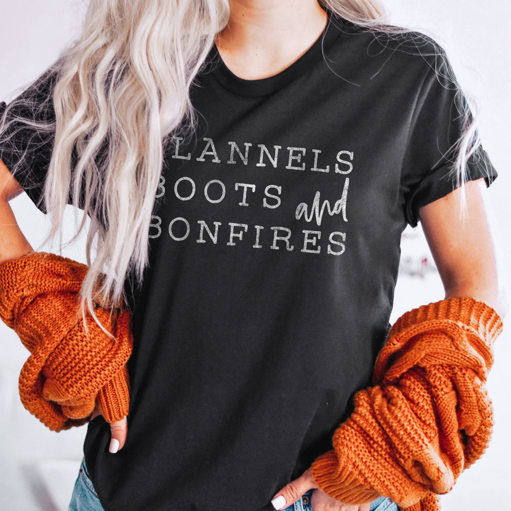 A young woman wearing a flannel boots and bonfires tee in black